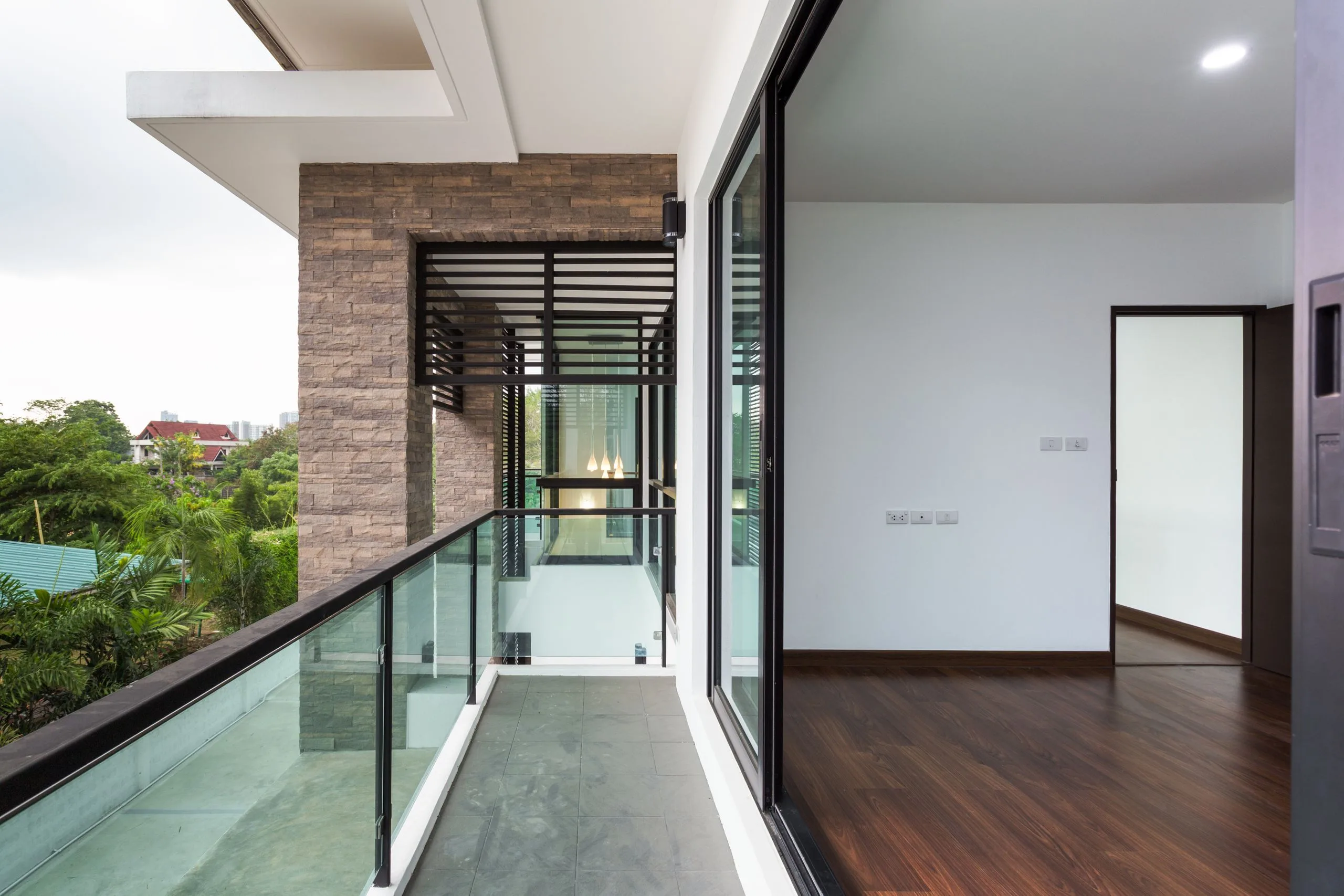 A balcony with glass doors and a wood floor.